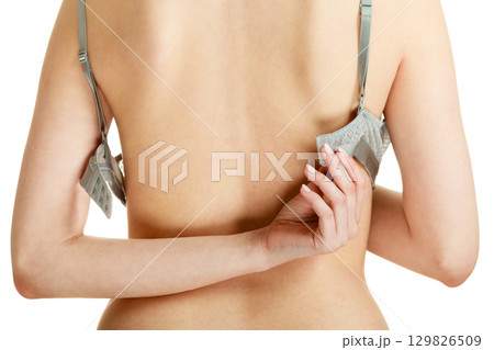 Attractive slim woman taking off grey bra Attractive slim woman taking off grey bra 129826509