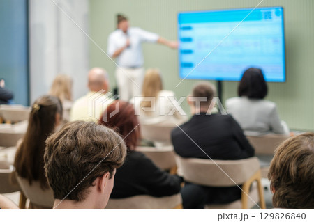 Audience attending a presentation in a modern conference room Audience attending a presentation in a modern conference room 129826840