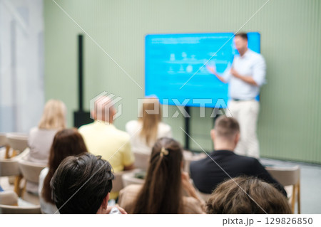 Presenter leading a business seminar with audience in focus Presenter leading a business seminar with audience in focus 129826850