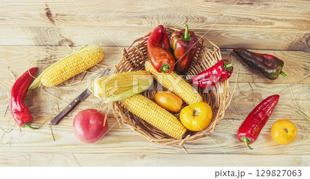 Fresh vegetables in a basket on a wooden background. Healthy food. Cooking from fresh farm vegetables for lunch. Fresh vegetables in a basket on a wooden background. Healthy food. Cooking from fresh farm vegetables for lunch. 129827063