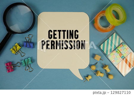 Getting Permission text with magnifying glass on blue background Getting Permission text with magnifying glass on blue background 129827110