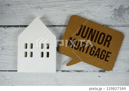 Junior Mortgage text with house models on wooden background Junior Mortgage text with house models on wooden background 129827169