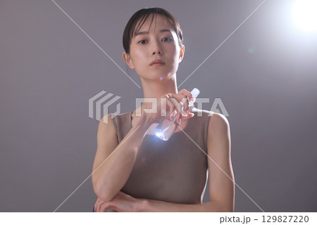 ビューティーイメージ 化粧水を持っている若い女性 ビューティーイメージ 化粧水を持っている若い女性 129827220