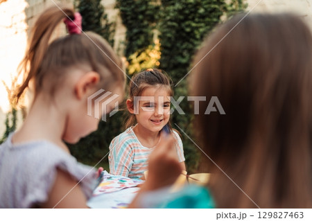 Children painting outdoors having fun together during a sunny day 129827463