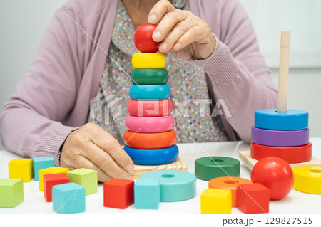 Alzheimer disease AD, Asian elderly woman patient suffering from dementia learn practical motor skills rehabilitation. Alzheimer disease AD, Asian elderly woman patient suffering from dementia learn practical motor skills rehabilitation. 129827515