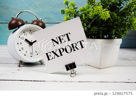 Net Export text written on paper card with alarm clock on wooden background 129827575