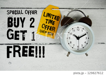 Buy 1 Get 1 Free!!! Special Offer text with alarm clock on wooden background 129827612