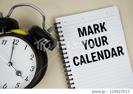 Mark Your Calendar text written on notepad with alarm clock Mark Your Calendar text written on notepad with alarm clock 129827613