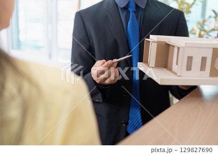 Real Estate Consultation. Agent presenting property model to client. 129827690