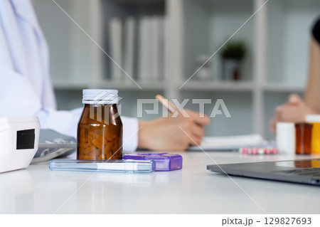 Healthcare Consultation. Doctor discussing medication with patient in modern clinic. Healthcare Consultation. Doctor discussing medication with patient in modern clinic. 129827693