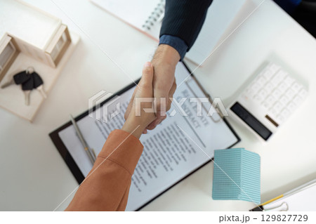 Real Estate Agreement. Client and agent shaking hands over a property contract. Real Estate Agreement. Client and agent shaking hands over a property contract. 129827729