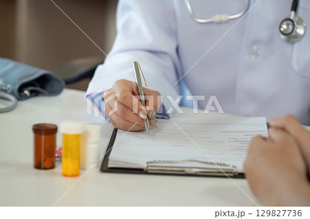 Doctor Writing Prescription. Medical professional documenting patient information in clinic. Doctor Writing Prescription. Medical professional documenting patient information in clinic. 129827736