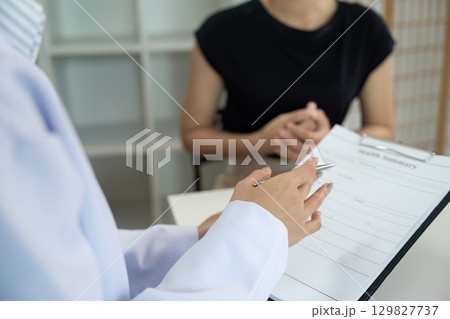 Patient Consultation. Doctor explaining health information to patient in office. Patient Consultation. Doctor explaining health information to patient in office. 129827737