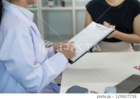Patient Care. Doctor documenting patient information during a consultation. Patient Care. Doctor documenting patient information during a consultation. 129827738