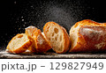 Ciabatta bread slices arranged on a dark surface 129827949