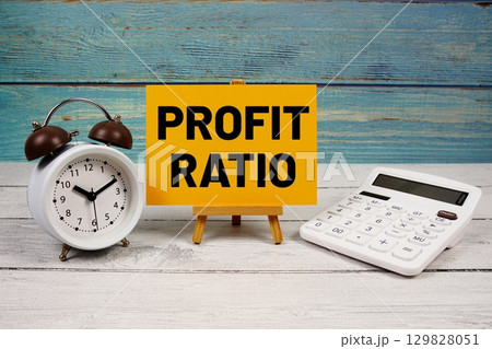 Profit Ratio text written on paper card with calculator and alarm clock on wooden background Profit Ratio text written on paper card with calculator and alarm clock on wooden background 129828051