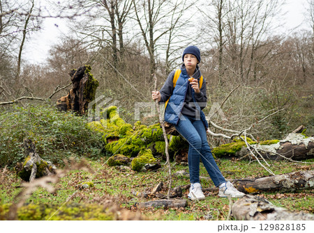 Backpacker resting on mossy log, consuming trail food while hiking through lush woodland landscape Backpacker resting on mossy log, consuming trail food while hiking through lush woodland landscape 129828185