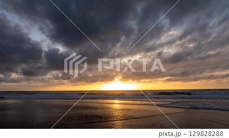 Golden sunset illuminating the shore of praia grande beach in Sintra, Portugal, creating a scenic seascape Golden sunset illuminating the shore of praia grande beach in Sintra, Portugal, creating a scenic seascape 129828288