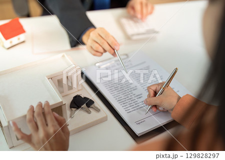 Real Estate Agreement. Client reviewing contract with agent's support. Real Estate Agreement. Client reviewing contract with agent's support. 129828297