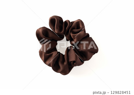 Dark brown fabric hair scrunchie isolated on white background, close-up Dark brown fabric hair scrunchie isolated on white background, close-up 129828451