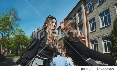 Two high school friends sharing a sweet kiss on the cheek to celebrate their affection and friendship 129828509