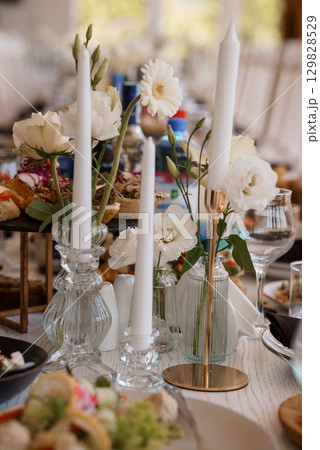 Elegant Wedding Table Setting with White Flowers and Candles. Rustic Wood Table with Crystal Glassware, Champagne, Snacks, Romantic Celebration Decor Elegant Wedding Table Setting with White Flowers and Candles. Rustic Wood Table with Crystal Glassware, Champagne, Snacks, Romantic Celebration Decor 129828529