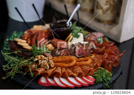 Gourmet Charcuterie Board with Artisanal Meats, Cheeses, Walnuts, and Berries on Slate Platter Dark and Moody Food Photography Gourmet Charcuterie Board with Artisanal Meats, Cheeses, Walnuts, and Berries on Slate Platter Dark and Moody Food Photography 129828604