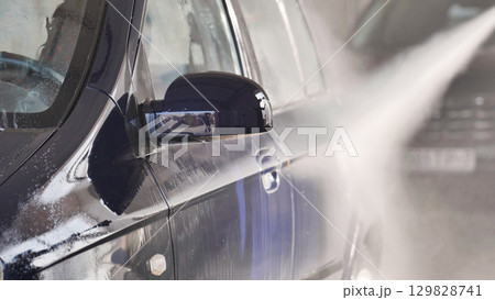 Water jet cleaning a car at car wash 129828741