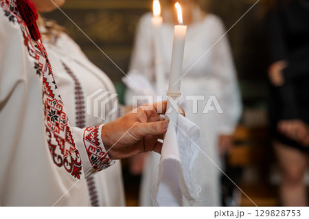Orthodox Church Ritual with Candles: Traditional Eastern European Ceremony, Liturgical Celebration, White Robes, Red Embroidery, Soft Lighting Orthodox Church Ritual with Candles: Traditional Eastern European Ceremony, Liturgical Celebration, White Robes, Red Embroidery, Soft Lighting 129828753