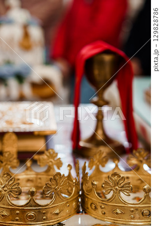 Golden Chalice and Sacred Objects in Eastern Orthodox Church Ritual, Red Cloth Drapery, Detailed Interior, Religious Ceremony Photography. 129828786