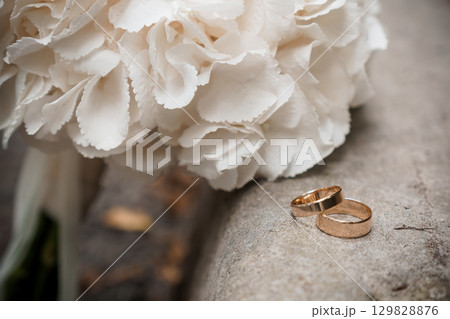 Romantic Wedding Rings with White Carnations Bouquet. Symbolizing Love, Commitment and Celebration in Soft Tones. 129828876