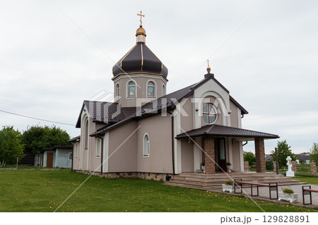 Eastern Orthodox Church Exterior: Beige Stone Building with Golden Dome Crosses, Modern Architecture, Cloudy Sky, Lush Green Lawn. 129828891