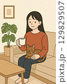リビングで猫と一息つく女性1 129829507