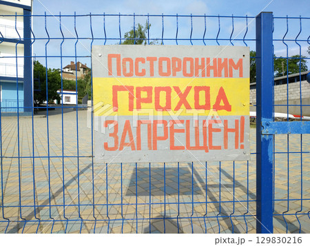 information sign on a fence with a sign prohibiting outsiders from entering 129830216