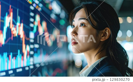 《AI画像》株価の上昇チャートを見る女性 129830270