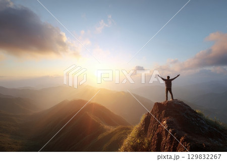 Person Standing on Cliff Edge with Arms Wide Open at Sunset Person Standing on Cliff Edge with Arms Wide Open at Sunset 129832267