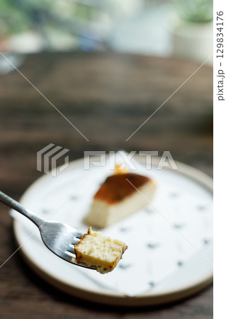 A small piece of cheese cake on a fork. A small piece of cheese cake on a fork. 129834176
