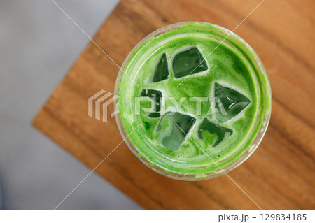 Cup of fresh matcha tea, green tea on wooden mat background. Cup of fresh matcha tea, green tea on wooden mat background. 129834185