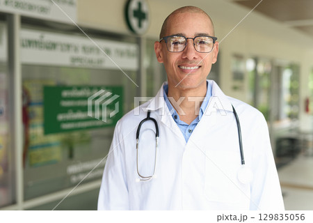 Doctor Standing Outside Medical Clinic Wearing White Lab Coat 129835056