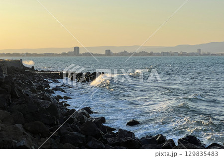 Sunset Waves Crashing Against Rocky Coastline in Nessebar, Bulgaria Sunset Waves Crashing Against Rocky Coastline in Nessebar, Bulgaria 129835483