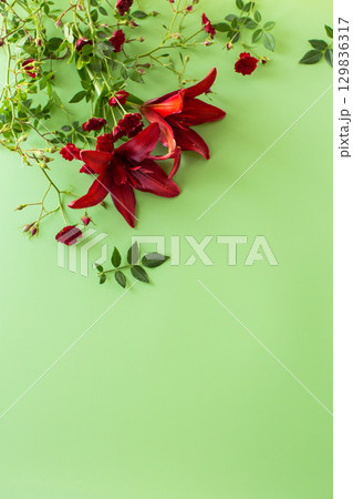 Lush red lilies with red roses on green background Lush red lilies with red roses on green background 129836317
