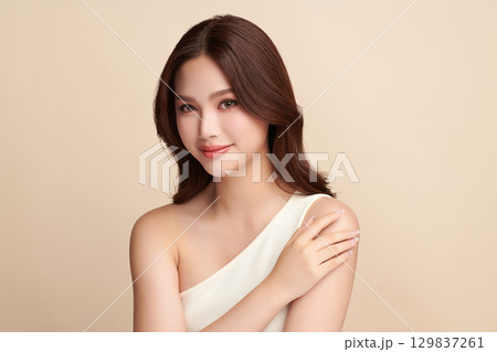A beautiful young Asian woman with clean, fresh skin against a beige background. Skincare, facial treatment, cosmetology, beauty, and spa. An elegant portrait of an Asian woman. A beautiful young Asian woman with clean, fresh skin against a beige background. Skincare, facial treatment, cosmetology, beauty, and spa. An elegant portrait of an Asian woman. 129837261