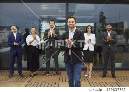 Team of corporate workers in formal clothing standing and clapping hands, meeting new colleague Team of corporate workers in formal clothing standing and clapping hands, meeting new colleague 129837765