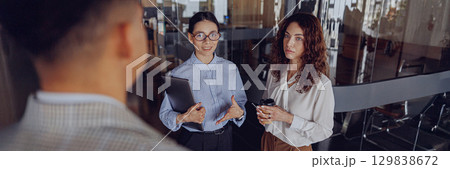 Participate in a dynamic business meeting in a modern office with high energy and collaboration Participate in a dynamic business meeting in a modern office with high energy and collaboration 129838672