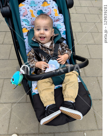 Smiling Baby in Stroller with Plaid Shirt 129839281