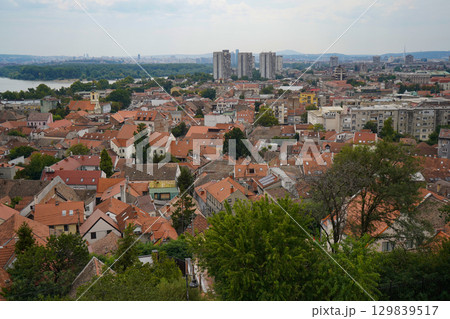 Wide panoramic view of Zemun with churches and red roofs along the Danube, Belgrade visible in the distance across the river Wide panoramic view of Zemun with churches and red roofs along the Danube, Belgrade visible in the distance across the river 129839517