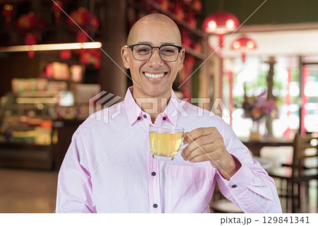 Bald Hispanic man wearing pink casual business shirt and eyeglasses in Chinese style tea house 129841341