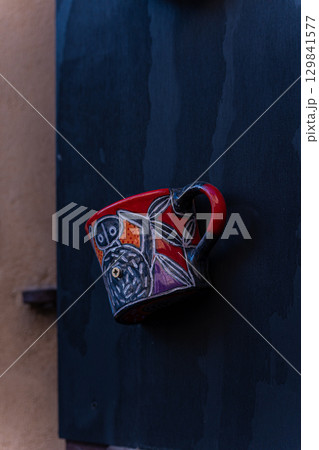 Ceramic cups as a handle on old door 129841577
