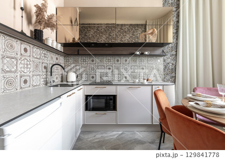 Modern Kitchen with Patterned Tiles and Elegant Dining Area Modern Kitchen with Patterned Tiles and Elegant Dining Area 129841778