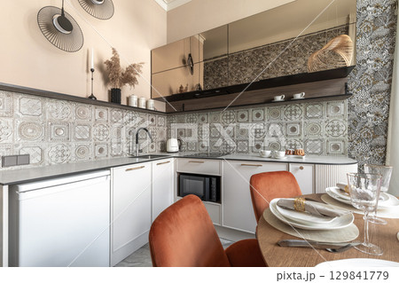Stylish Kitchen Interior with Patterned Tiles and Dining Setup 129841779